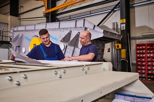 Industriemechaniker bekommt Aufgaben anhand der Zeichnung