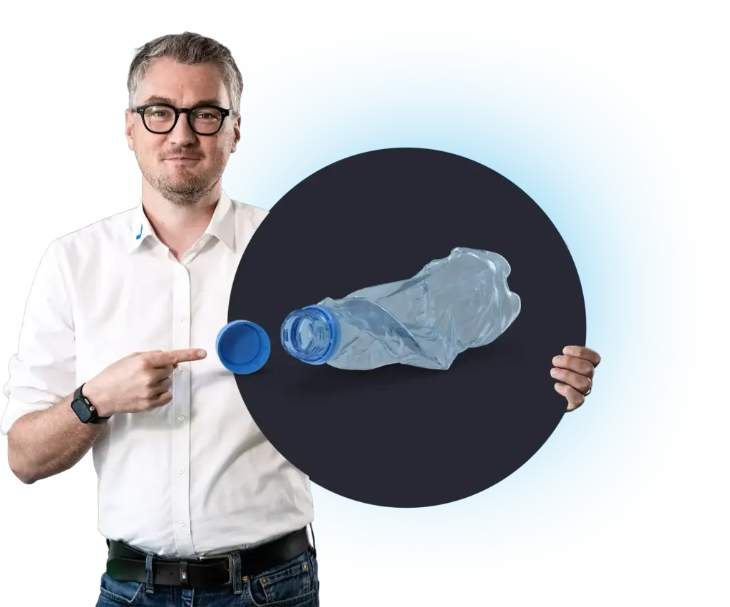 Een man wijst naar een verfrommelde plastic fles met dop, MODUL6 RZ.