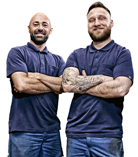 Twee mannen in blauwe poloshirts met de armen over elkaar.