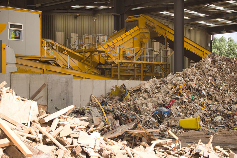 Een blik op een SPALECK-zeefmachine in een recyclinginstallatie voor gemengd bouwafval. Op de voorgrond ziet u het bronmateriaal.