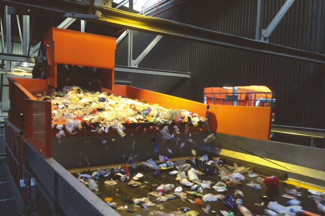Een triltrechter voert het gerecyclede materiaal, namelijk lichte verpakkingen, naar een NIR-sorteermachine. Het materiaal wordt over de gehele breedte goed verdeeld, wat zorgt voor een optimale toevoer.