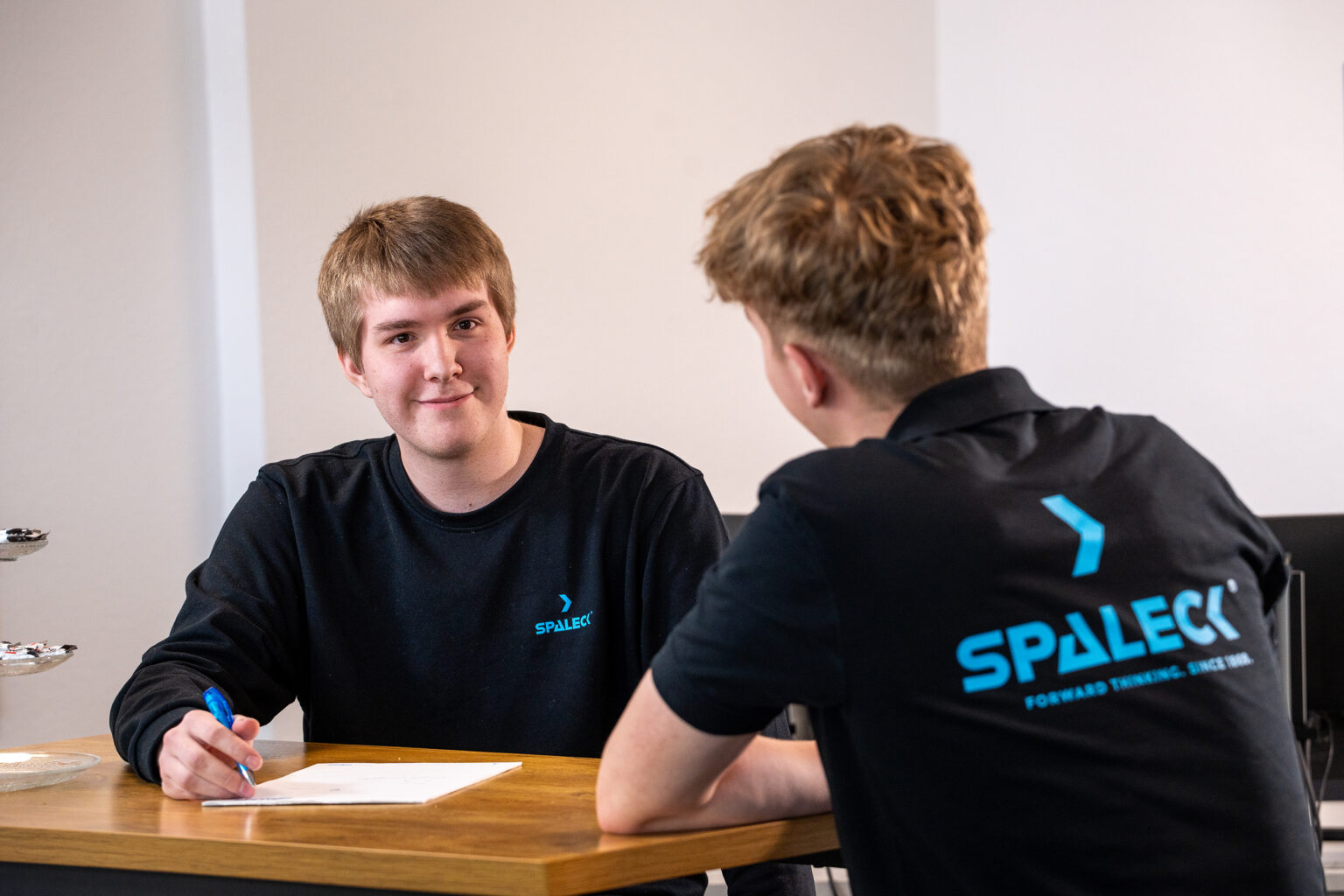 Twee jonge mannen in gesprek bij SPALECK AUSBILDUNG.