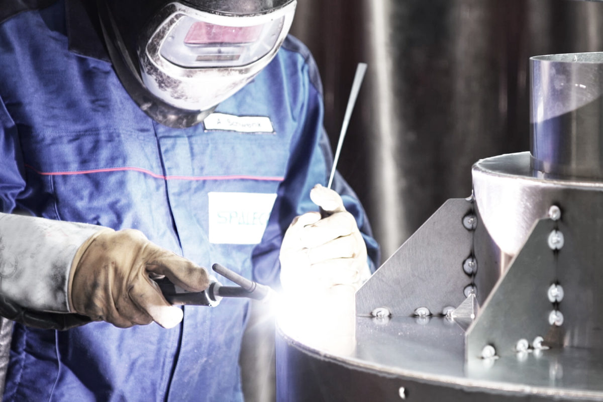 Een lasser werkt aan een onderdeel van een gasturbine.