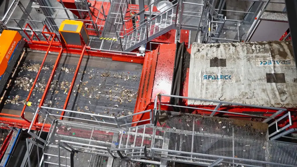 Een zeefmachine met spanassen () vóór een sorteermachine in een recyclinginstallatie voor huishoudelijk afval. De SPALECK-zeefmachine met spanassen levert nauwkeurig gezeefd materiaal. Het uitzeven van de fijne deeltjes zorgt ervoor dat de daaropvolgende sensorsortering (Tomra-machine) optimaal kan functioneren.
