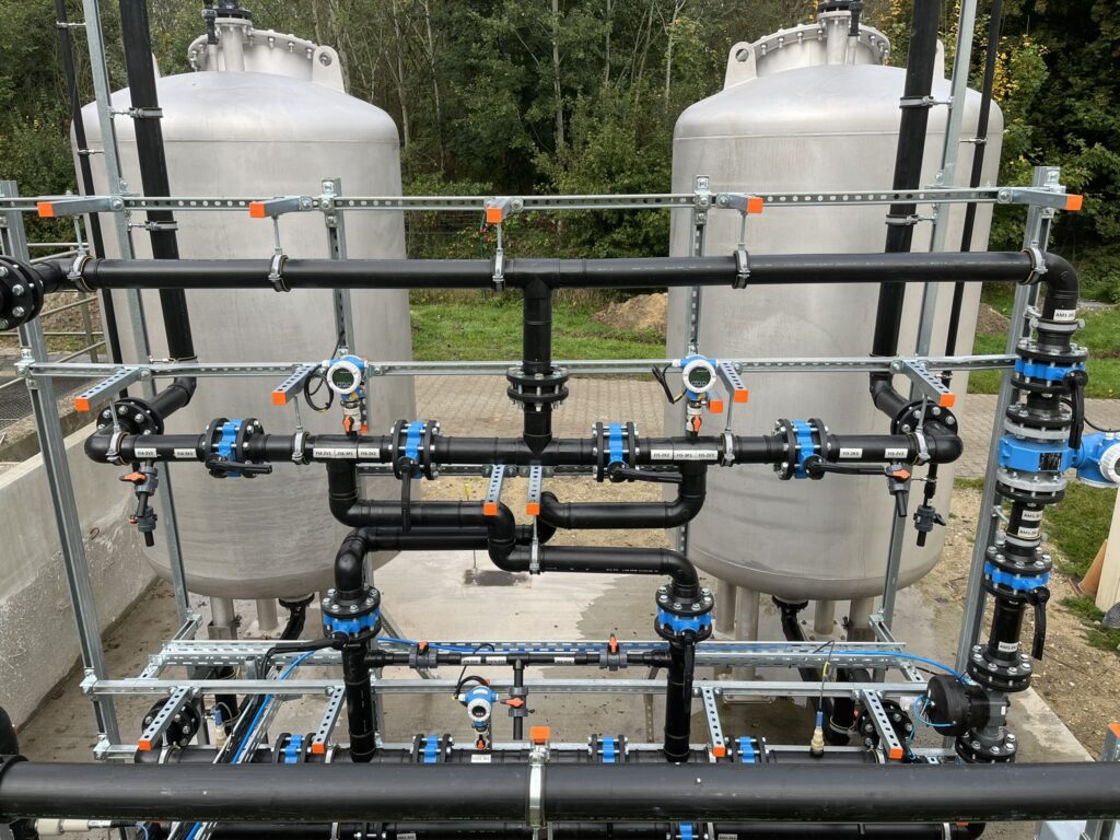 Installatie voor de waterzuivering van ruw water en bronwater, met leidingen en tanks in de open lucht.