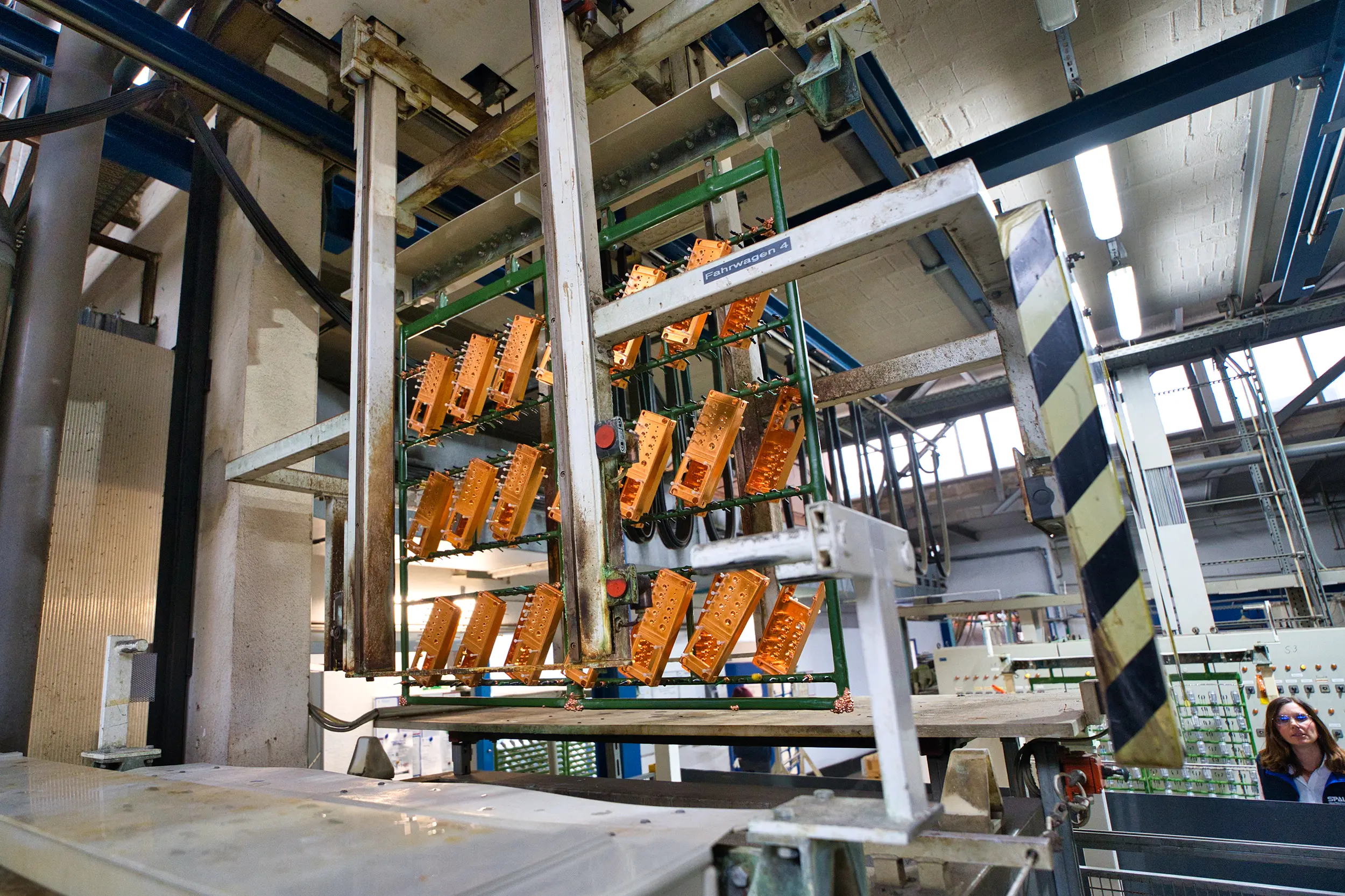 Industriële installatie voor de oppervlaktebehandeling van metalen onderdelen in een fabriekshal.