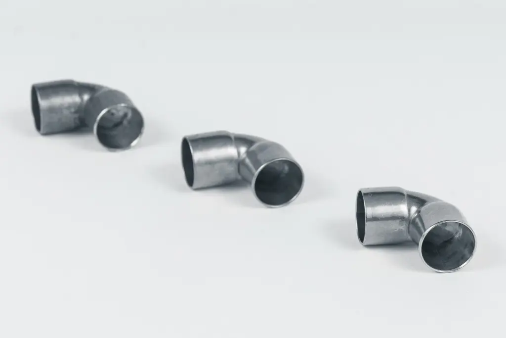 Drie gebogen metalen buizen op een witte achtergrond.