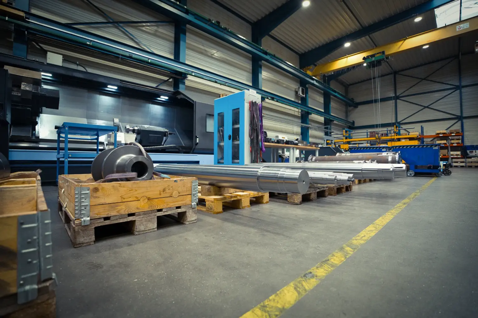 Industriehal met langdraaiwerkstukken op pallets.