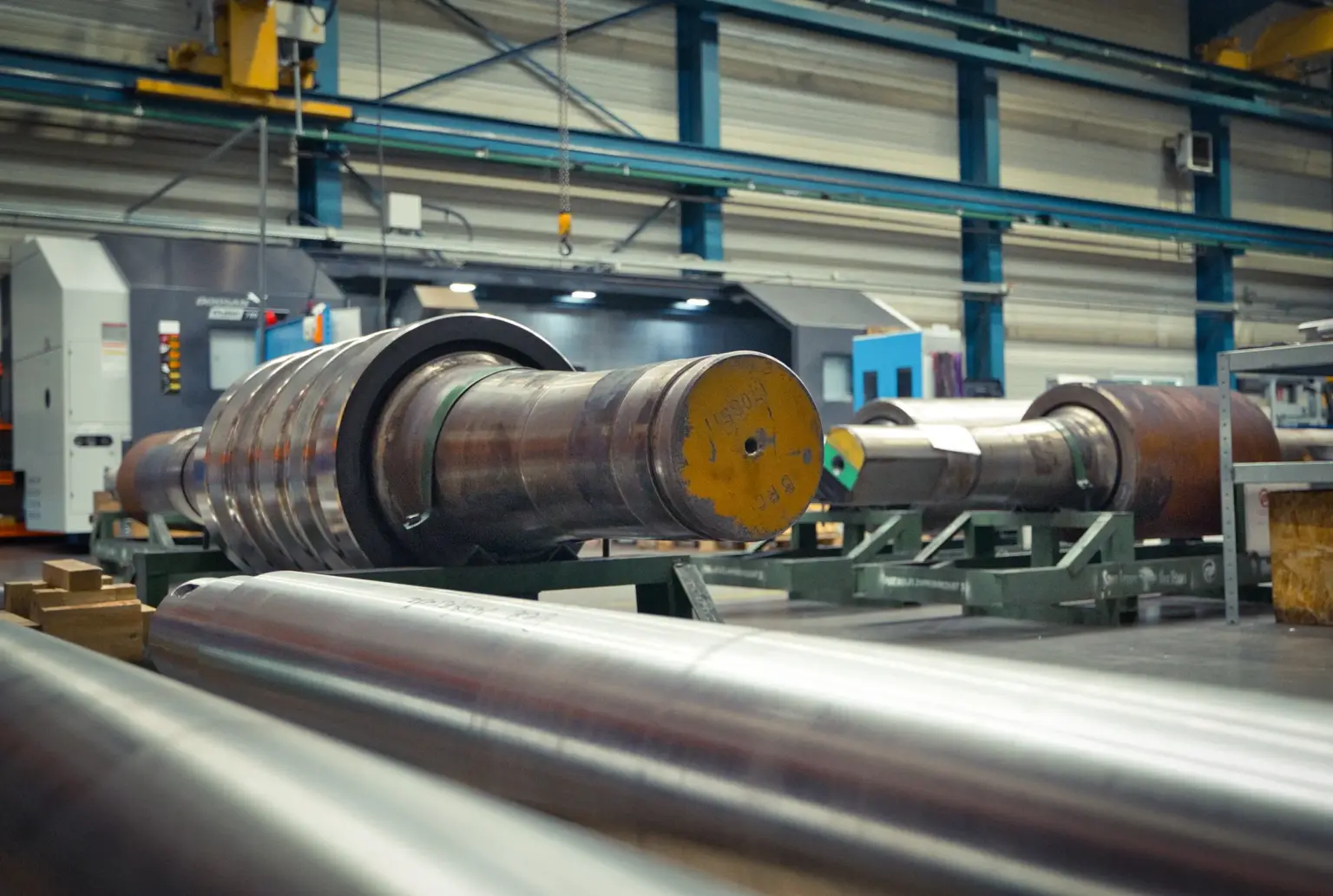 Grote metalen cilinders in een fabriekshal, geschikt voor langdraaiwerkstukken.