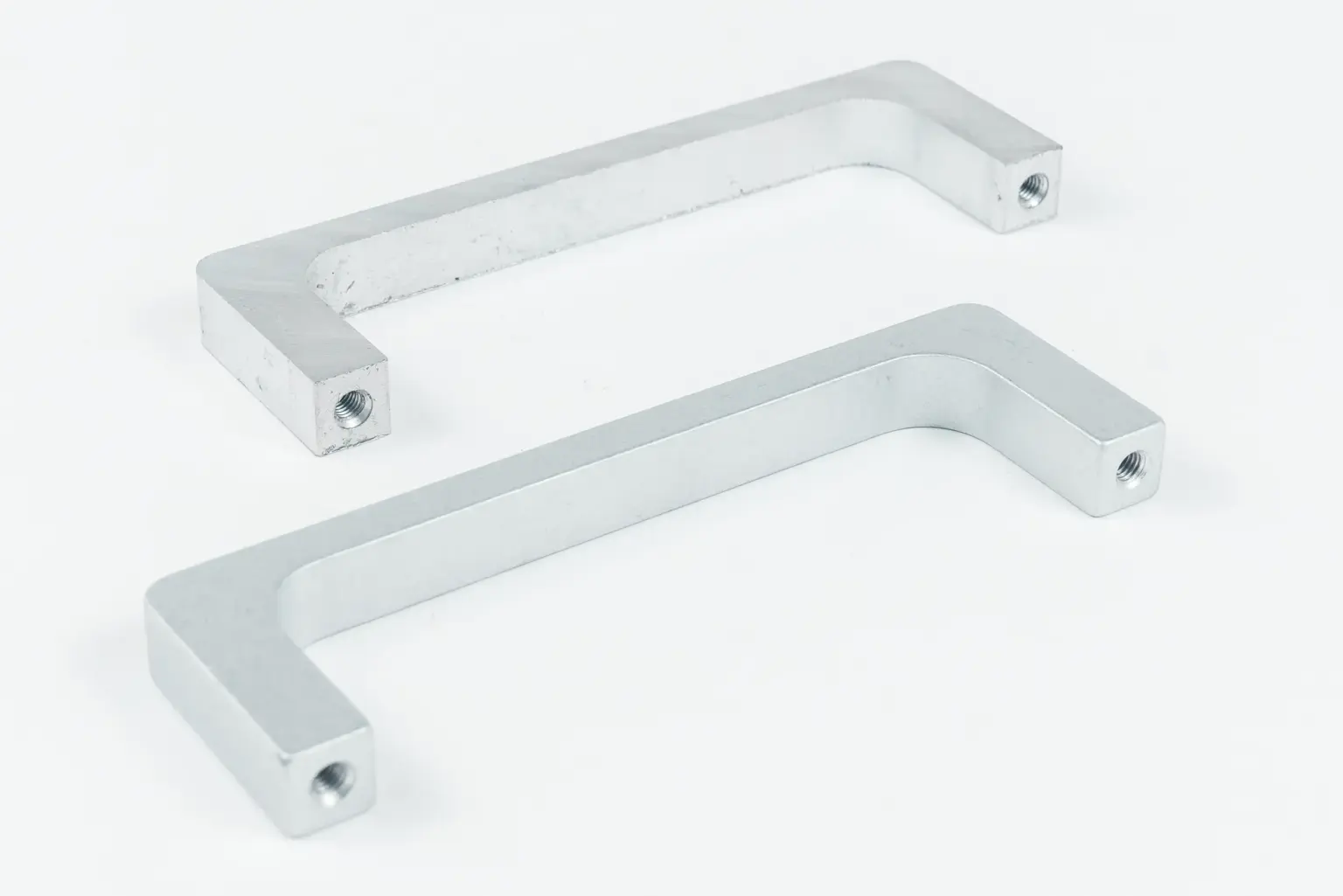Twee metalen handgrepen op een witte achtergrond.