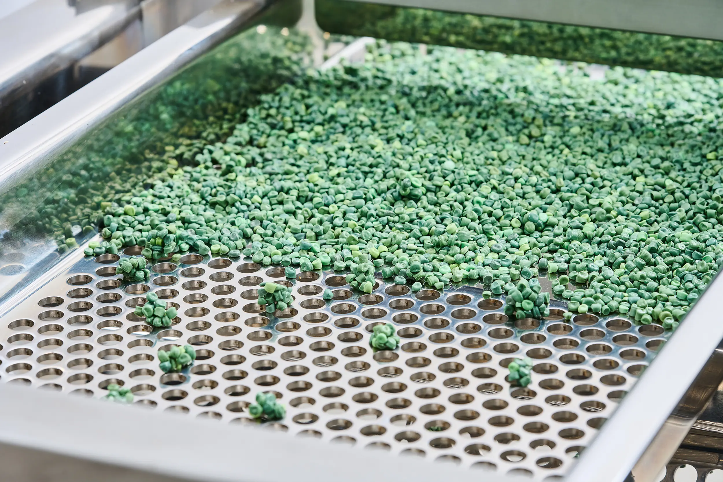 Groene korrels op een korrelzeefmachine die een nauwkeurige scheiding mogelijk maakt.