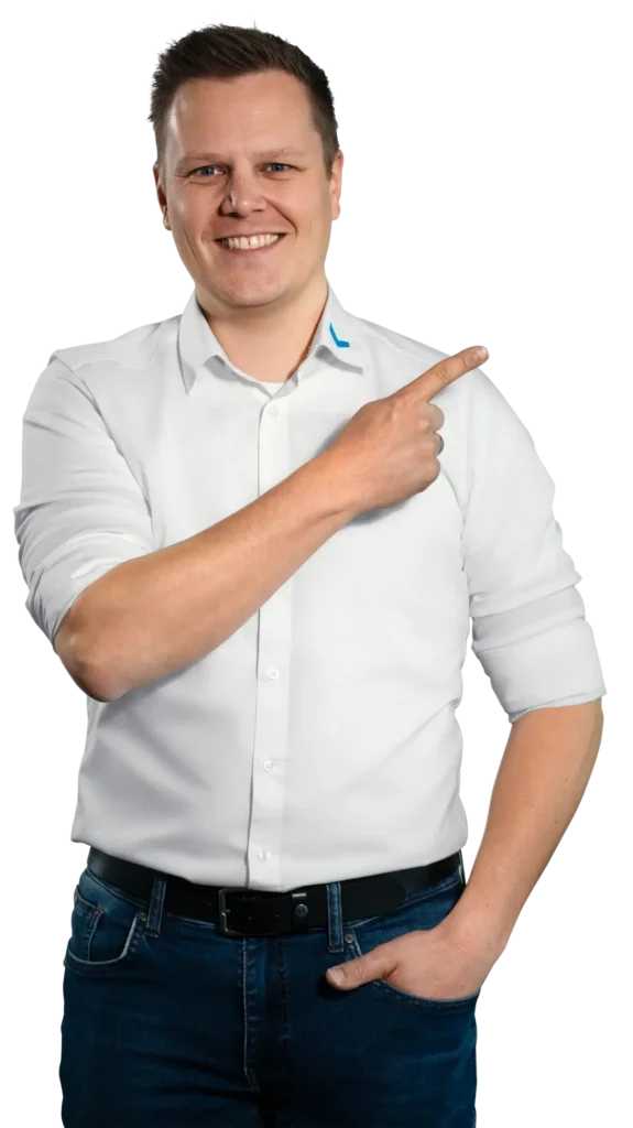 Een man in een wit overhemd wijst glimlachend naar rechts.
