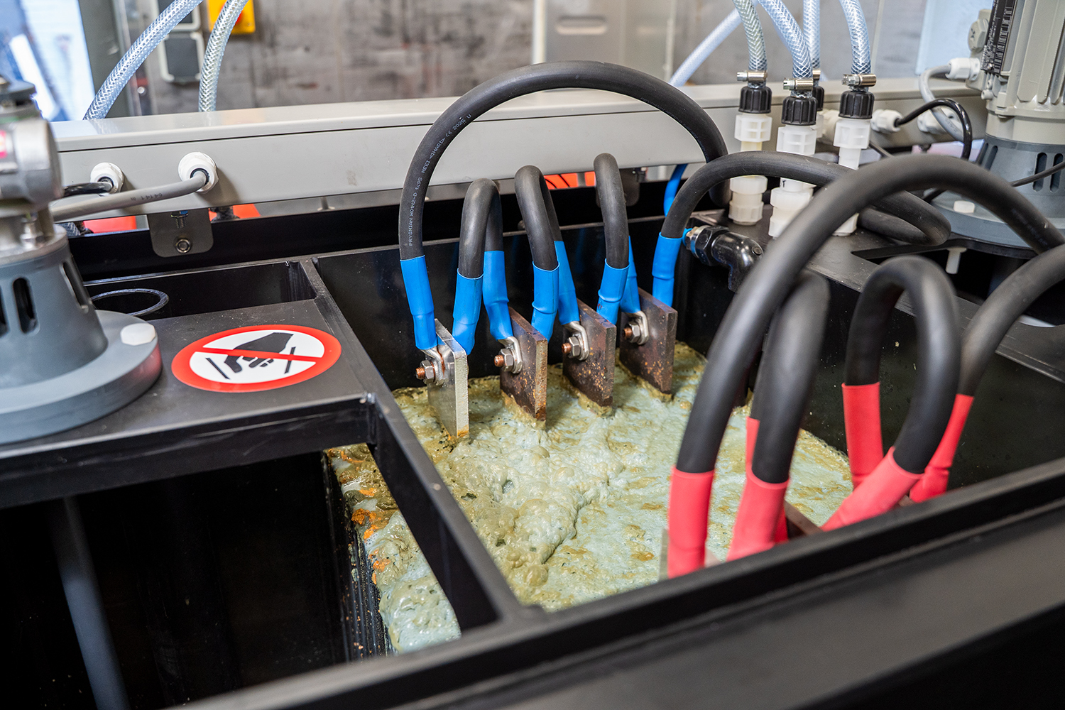 Close-up van een elektrocoagulatiesysteem in werking. Hierop zijn de elektrische lamellen in het vervuilde water te zien.