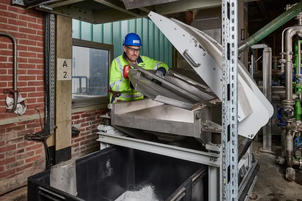 De productieleider van een kunststoffabrikant bedient een SPALECK-overlengteafscheider – een zeefmachine die overlengtes betrouwbaar afscheidt