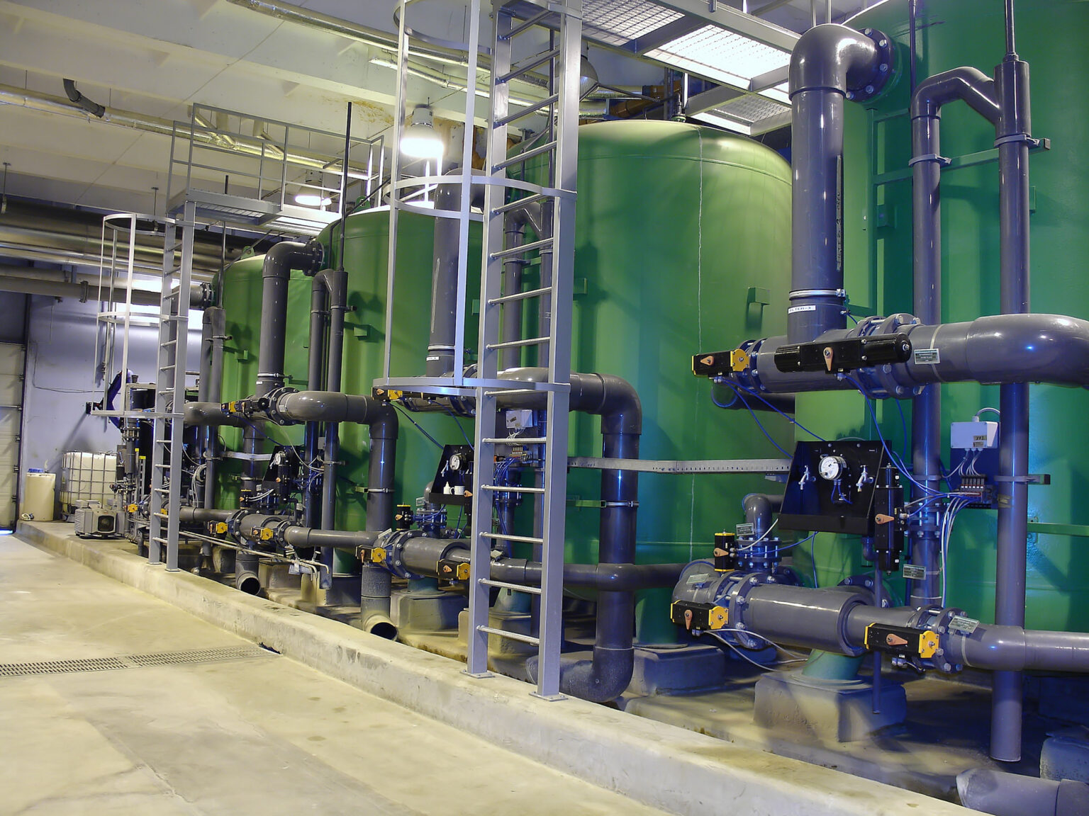 Vier groene tanks voor neerslag en flocculatie bij de waterzuivering